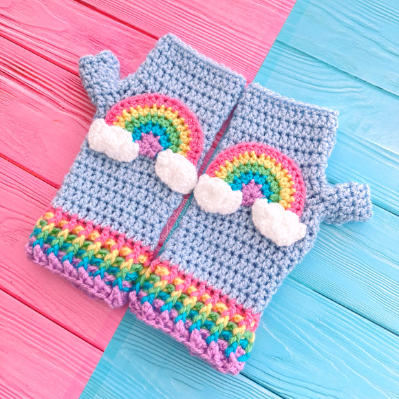 Baby Blue crochet fingerless gloves with pastel rainbow striped cuffs and a pastel rainbow motif with clouds at both ends on the centre of each glove by VelvetVolcano. Kawaii Fairy Kei Style Hand Warmers