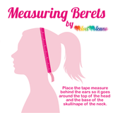 Measuring Berets graphic by VelvetVolcano featuring a light pink silhouette of a person with their hair tied up and a dark pink tape measure wrapped around their head. There is dark pink text overlay that says "Place the tape measure behind the ears so it goes around the top of the head and the base of the skull/nape of the neck.