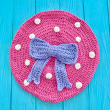 Bubblegum pink crochet beret with cream polka dots and lavender bow in the centre by VelvetVolcano