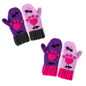 A set of crochet mittens with a Frankenstein's Monster & Zombie Cat inspired design, with one lilac mitten, one violet mitten, black embroidered stitch details and hot pink heart shaped paws - NecroKitty Mittens by VelvetVolcano