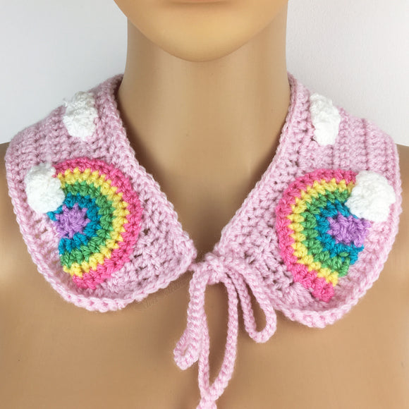 Baby Pink crochet Peter Pan style detachable collar with tie closure, repeating white cloud pattern and pastel rainbow with a cloud at the end motif of each lapel. Pastel Rainbow Cloud Collar (Baby Pink) by VelvetVolcano