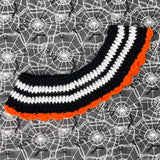 Black and white striped crochet Peter Pan style collar with orange scallop trim around the bottom edge and halloween inspired jack o' lantern appliques on the lapels of the collar. Pumpkin Stripe Collar by VelvetVolcano