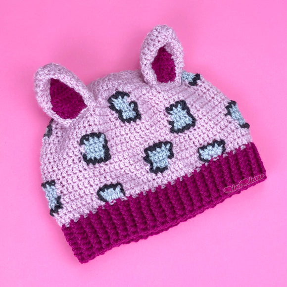 Baby pink crochet cat ear hat with dark pink inner ears and bottom rib and light grey and dark grey leopard print on the baby pink main part of the hat. Leopard Kitty Beanie (Custom Colour) by VelvetVolcano