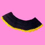 The back of a VelvetVolcano Sunflower Collar, which is a crocheted black Peter Pan collar with a yellow scallop trim.