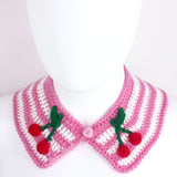 Bubblegum pink and white striped Peter Pan style detachable crochet collar with red and green cherry appliques on the lapels of the collar and a pink heart shaped button fastening. Cherry Stripe Collar by VelvetVolcano