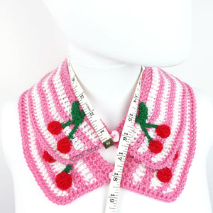 Bubblegum pink and white striped Peter Pan style detachable crochet collar with red and green cherry appliques on the lapels of the collar and a pink heart shaped button fastening. Cherry Stripe Collar by VelvetVolcano