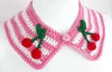 Bubblegum pink and white striped Peter Pan style detachable crochet collar with red and green cherry appliques on the lapels of the collar and a pink heart shaped button fastening. Cherry Stripe Collar by VelvetVolcano