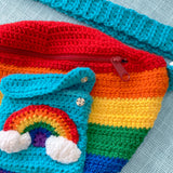 Bright rainbow striped crochet fanny pack with turquoise pocket and rainbow cloud detail. Bright Rainbow Stripe Cloud Pocket Bum Bag by VelvetVolcano