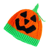 Halloween inspired orange crochet hat with contrasting neon green ribbed bottom section, neon green stem and a black carved jack o' lantern face on the main part of the hat. Pumpkin Beanie by VelvetVolcano